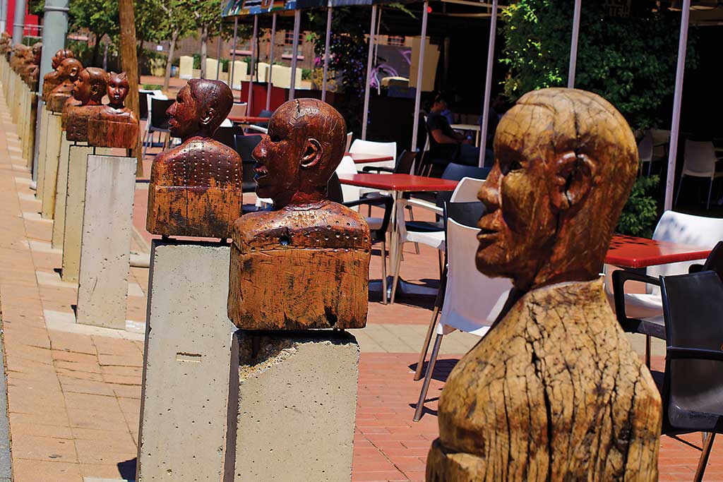 Wooden Heads in Newtown Representing African Diversity by Jaxons