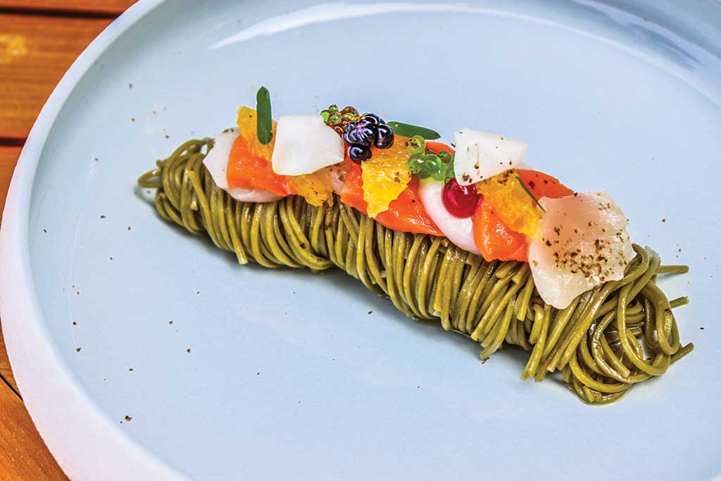 A medley of sashimi and caviar on top of green tea soba noodles