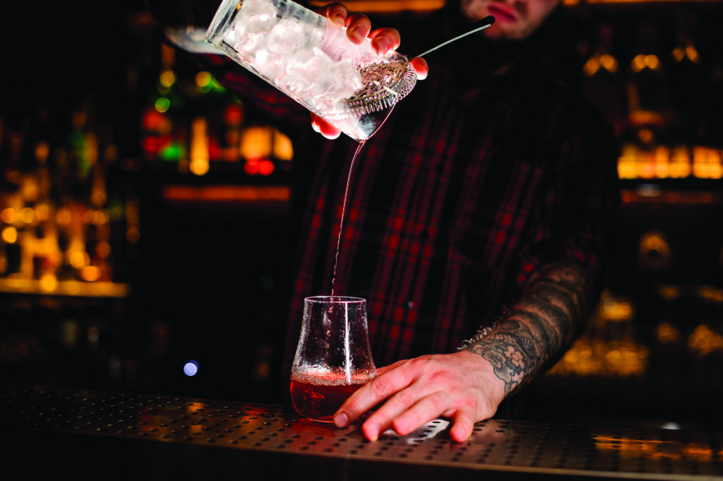 Bartender Pouring a Sazerac Cocktail (Photo by Maksym Fesenko)